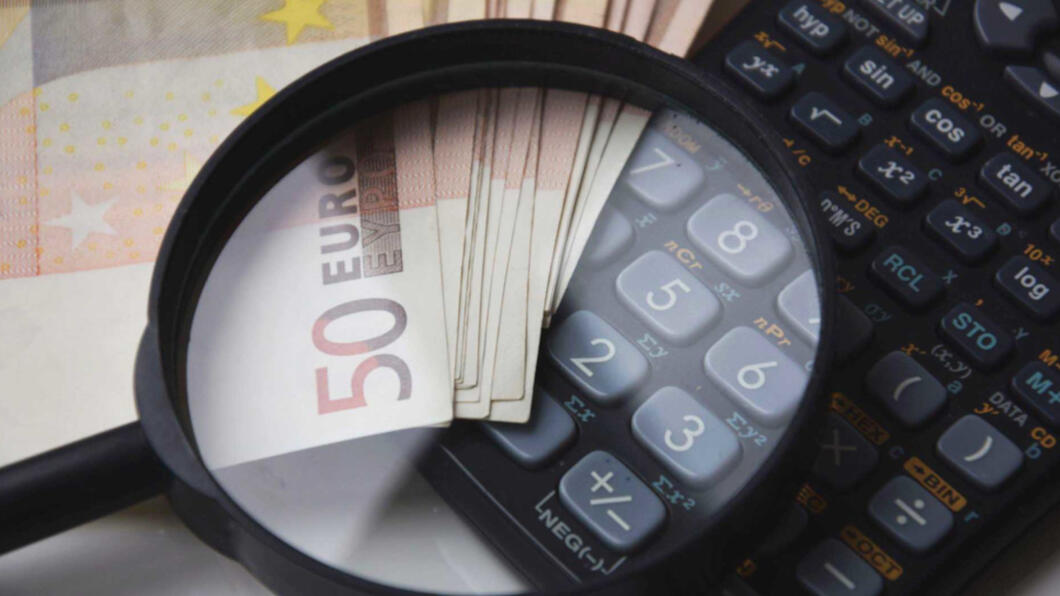 Financieel stockfoto met loep, rekenmachine en vijftig euro biljet