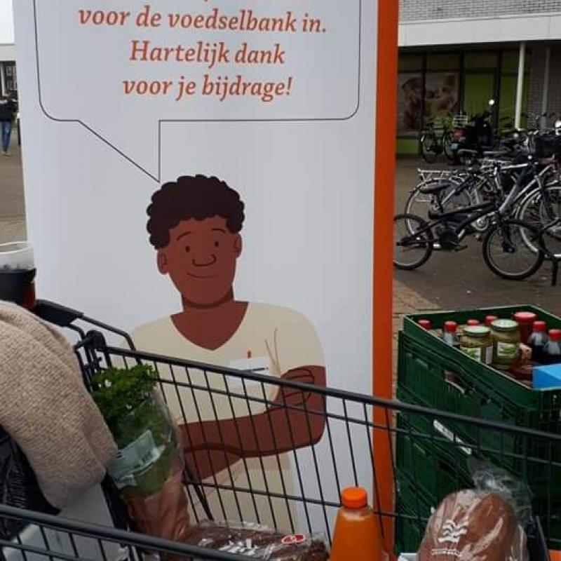 Bord Voedselbank en gevuld winkelwagentje